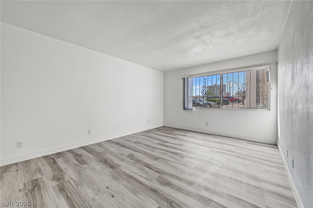 1405 Vegas Valley Drive, #187, Las Vegas, NV 89169 Gleaming wood-look floors anchor this versatile room illuminated by natural light.