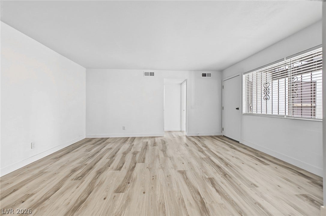 1405 Vegas Valley Drive, #187, Las Vegas, NV 89169 Crisp white walls pair with wide-plank flooring in this versatile, sunlit living area.