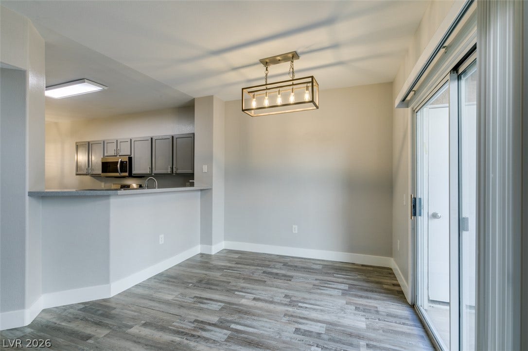 2001 Jade Creek Street, #105, Las Vegas, NV 89117 A modern light fixture illuminates the dining area adjacent to the kitchen counter.