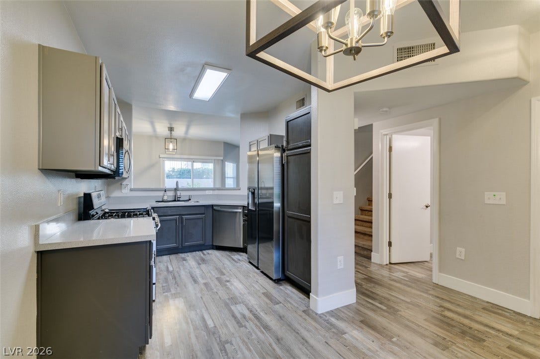 2001 Jade Creek Street, #105, Las Vegas, NV 89117 Gleaming wood-look flooring sets an inviting tone in this open-concept kitchen.