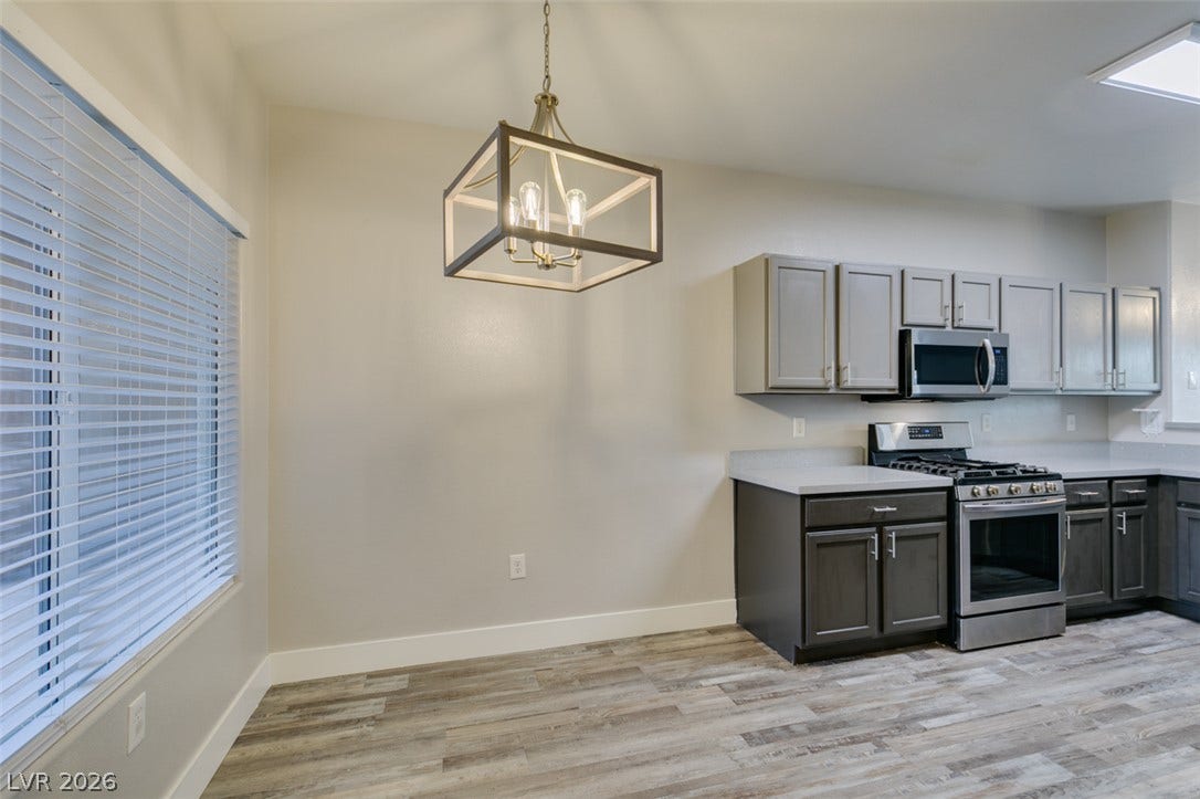 2001 Jade Creek Street, #105, Las Vegas, NV 89117 An open dining area flows effortlessly into the modern kitchen with wood-look flooring throughout.