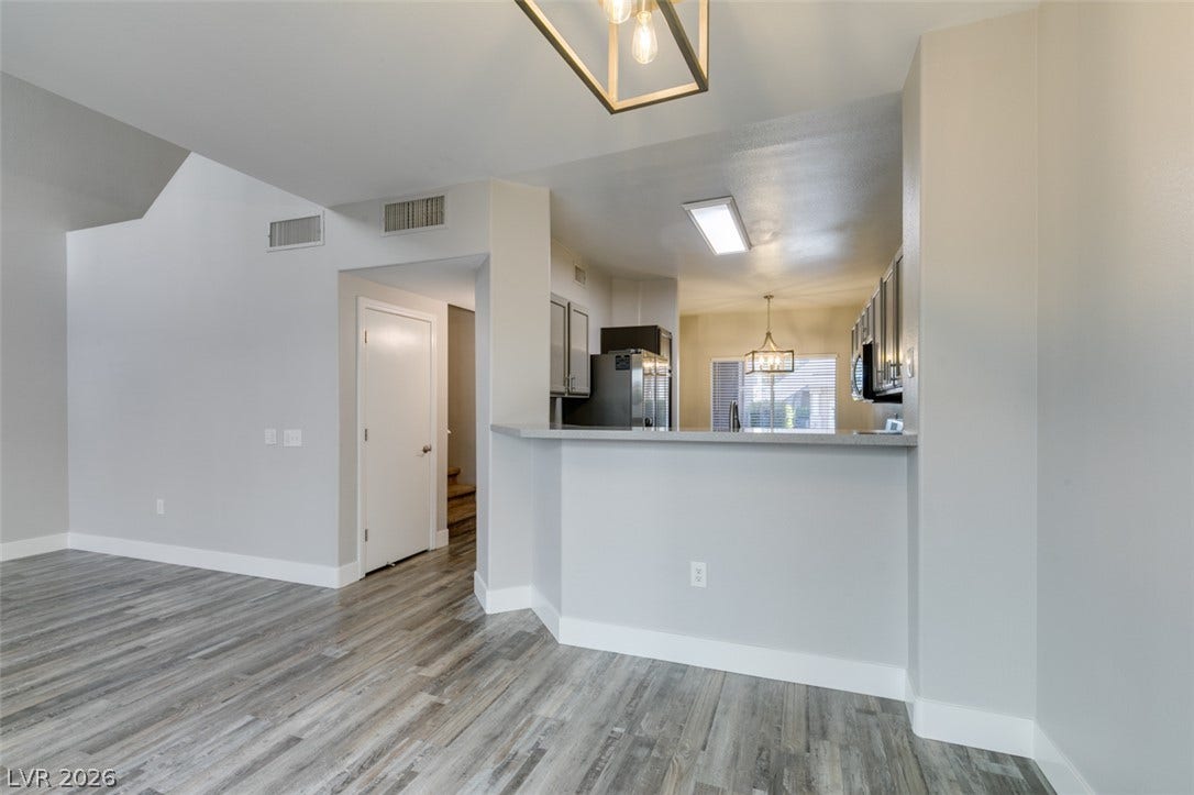 2001 Jade Creek Street, #105, Las Vegas, NV 89117 Plank flooring runs through an open floorplan connecting the living space and kitchen.