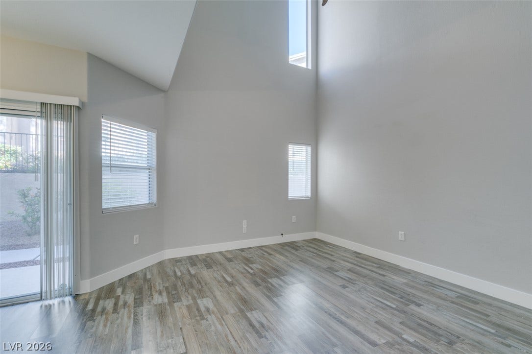 2001 Jade Creek Street, #105, Las Vegas, NV 89117 Vaulted ceilings soar over a light-filled living area featuring modern wood-look flooring.