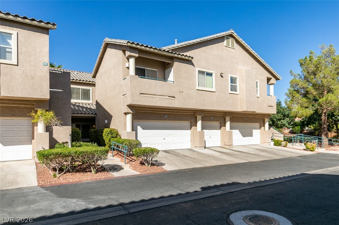 2001 Jade Creek Street, #105, Las Vegas, NV 89117 Stucco exteriors and multiple garages define this multi-level residential structure under clear blue skies.