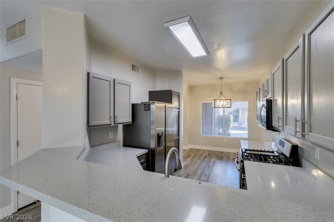 2001 Jade Creek Street, #105, Las Vegas, NV 89117 Gleaming quartz countertops pair with custom cabinetry in this thoughtfully designed culinary workspace.