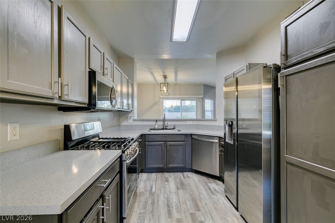 2001 Jade Creek Street, #105, Las Vegas, NV 89117 Smooth solid-surface countertops pair with dual-tone cabinetry and modern stainless steel appliances.