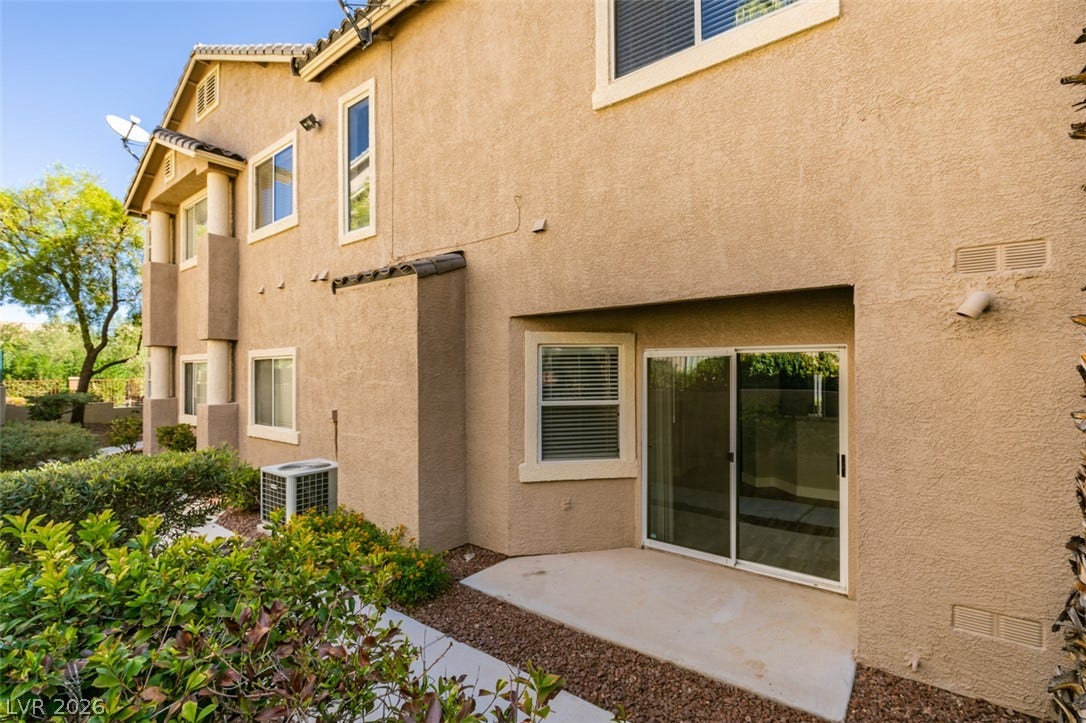 2001 Jade Creek Street, #105, Las Vegas, NV 89117 Sliding glass doors open onto a concrete patio surrounded by low-maintenance landscaping.