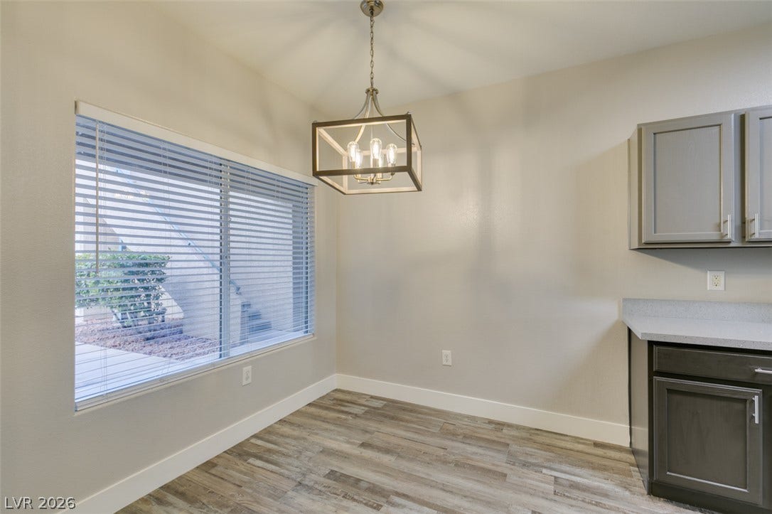 2001 Jade Creek Street, #105, Las Vegas, NV 89117 An inviting breakfast area highlights wood-look flooring next to a modern kitchen workspace.