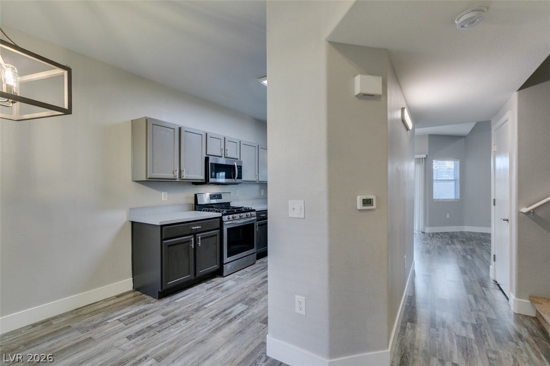 2001 Jade Creek Street, #105, Las Vegas, NV 89117 An open layout connects the kitchen to the main living areas through modern plank flooring.