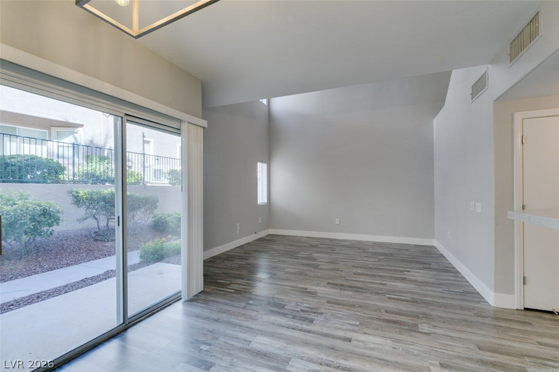 2001 Jade Creek Street, #105, Las Vegas, NV 89117 Sliding glass doors open to the patio from this spacious living area with wood flooring.