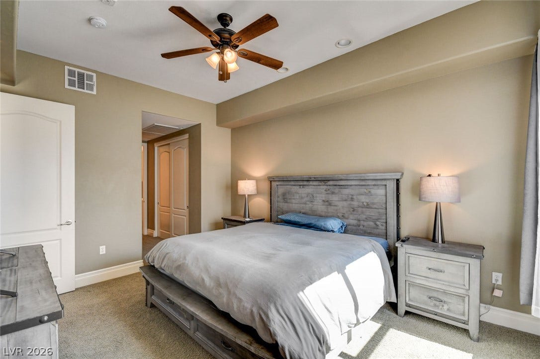 Comfortable sleeping space featuring tray ceiling details.