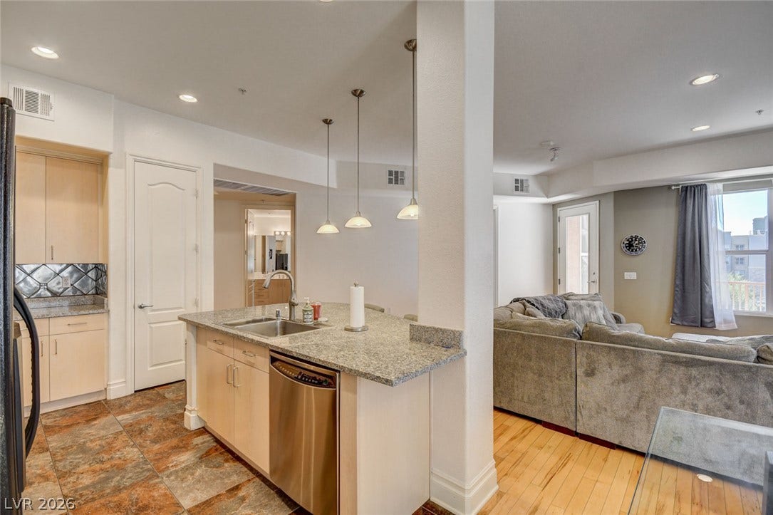 Gleaming granite countertops and multi-toned flooring define this functional open kitchen design.