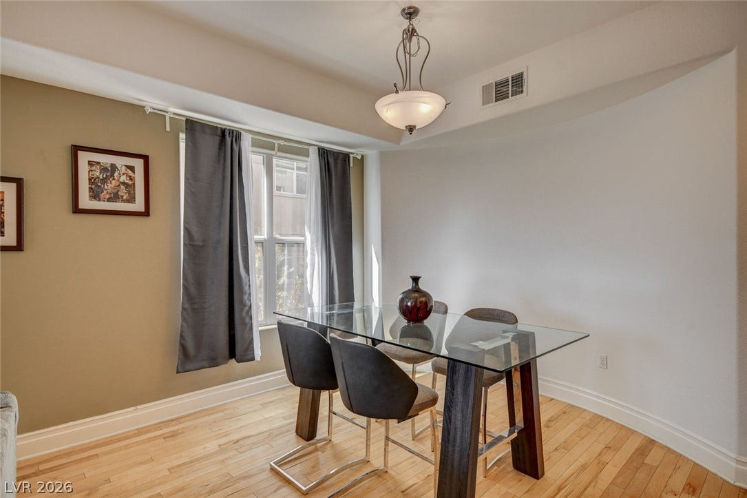 Hardwood floors and a tray ceiling define this elegant dining area.