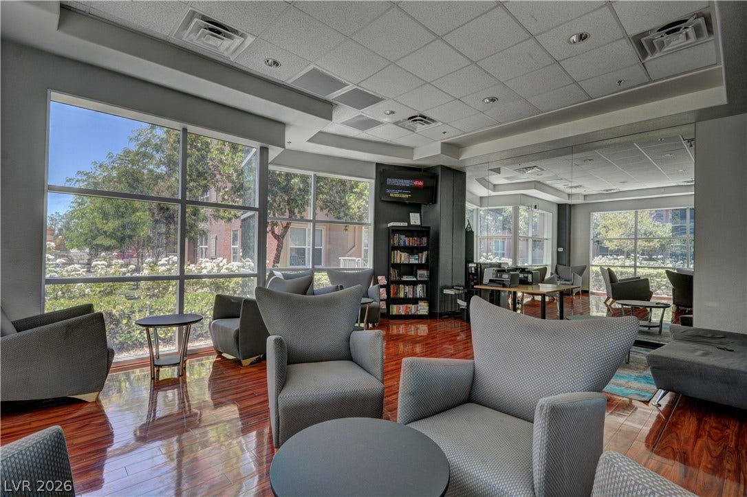 Hardwood floors and floor-to-ceiling windows create a bright, inviting communal space.