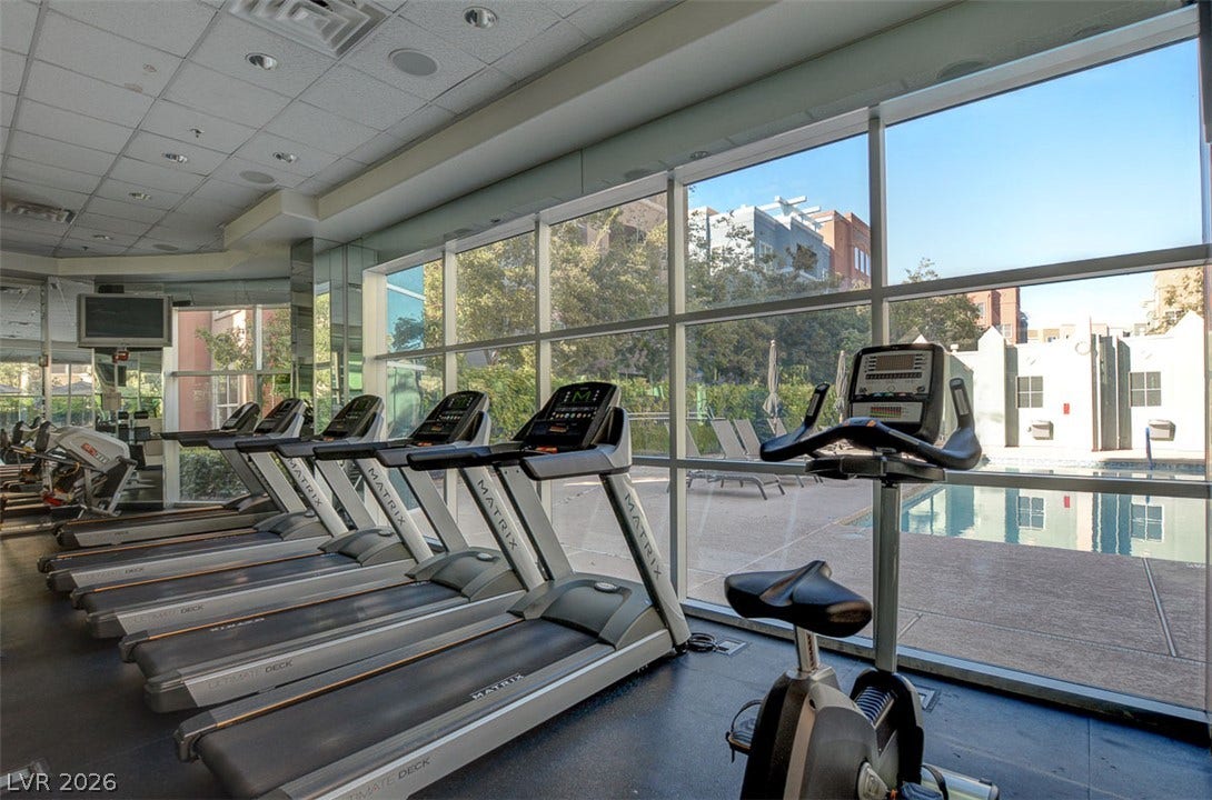 Floor-to-ceiling windows flood the fitness center with natural light while offering pool views.