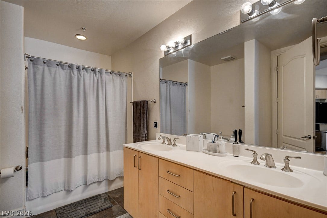 A spacious double vanity and a tub-shower combination anchor this well-appointed bathroom.