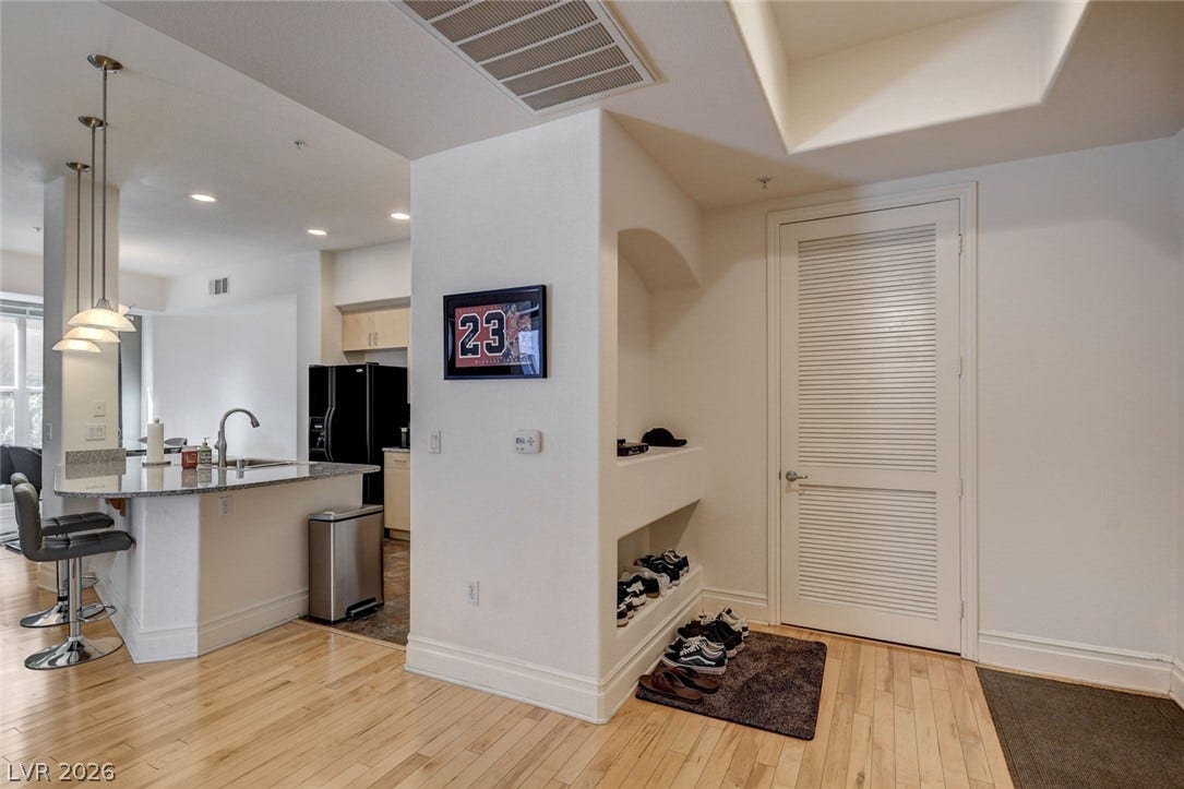 Smooth hardwood floors and custom wall niches define this welcoming entrance space.