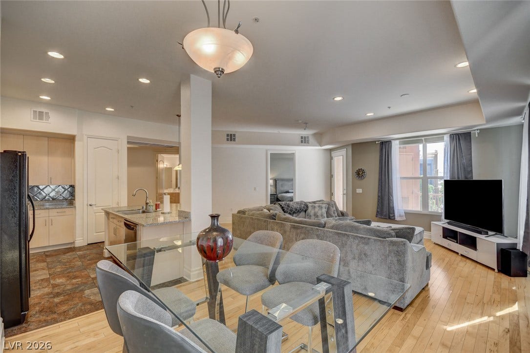 Hardwood floors and recessed lighting enhance the fluid, open layout.