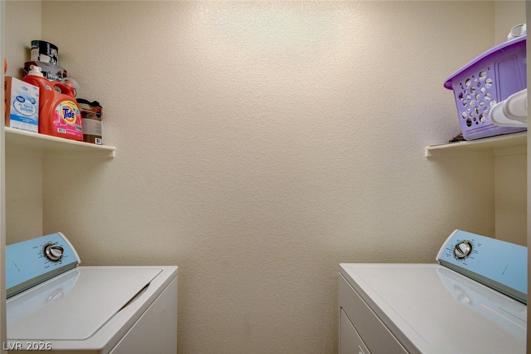 A dedicated laundry space features full size washer and dryer with built-in shelving overhead.