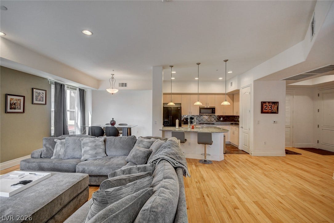 Warm hardwood flooring flows seamlessly throughout this spacious open-concept living area.