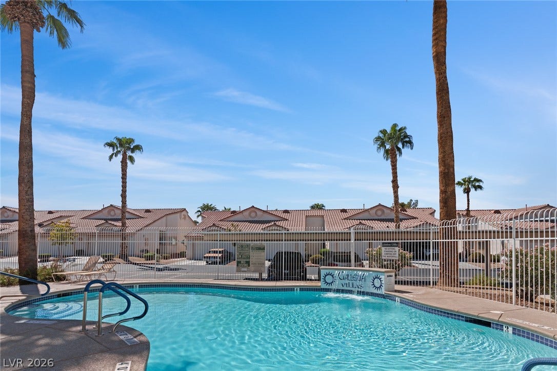 855 N Stephanie Street, #2615, Henderson, NV 89014 A sparkling community swimming pool sits enclosed by a security fence under clear blue skies.
