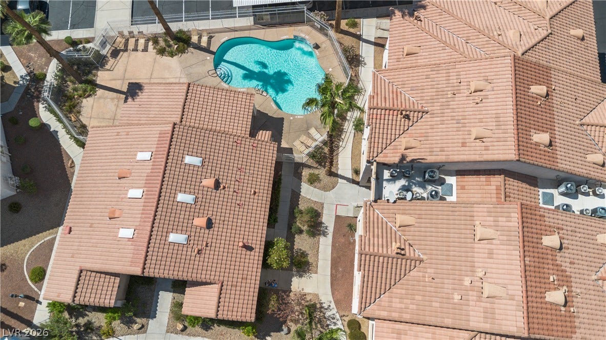855 N Stephanie Street, #2615, Henderson, NV 89014 An aerial perspective showcases Spanish tile roofing alongside a pristine community swimming pool.