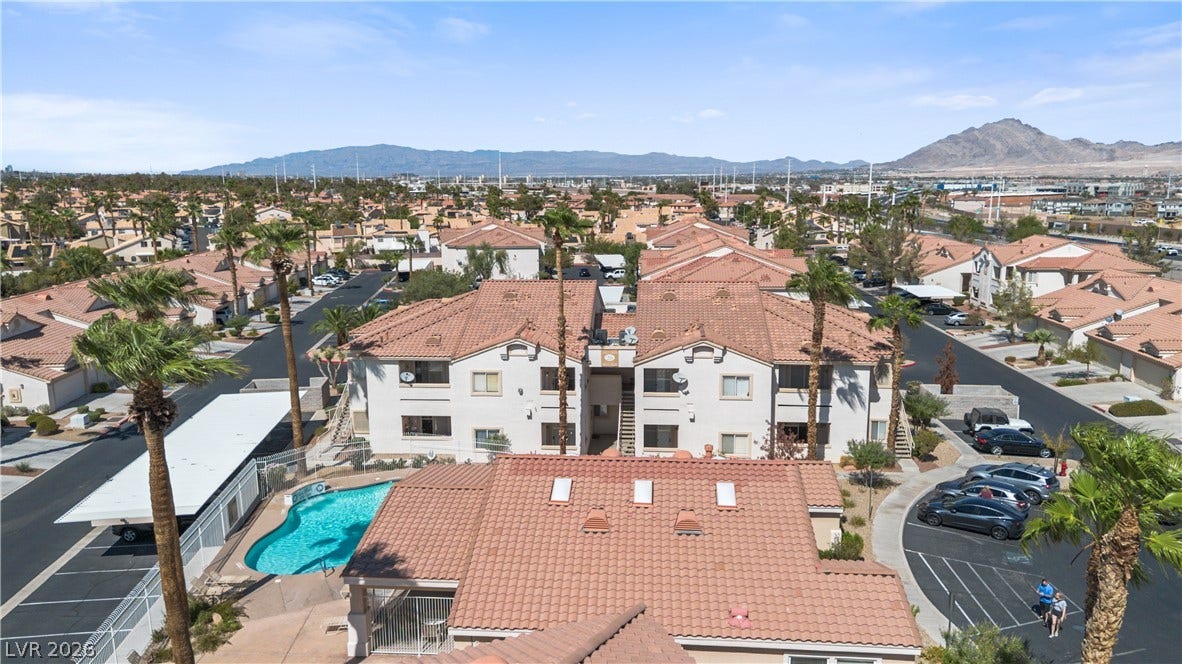 855 N Stephanie Street, #2615, Henderson, NV 89014 Distant mountains frame this residential community with tiled roofs and a central swimming pool.