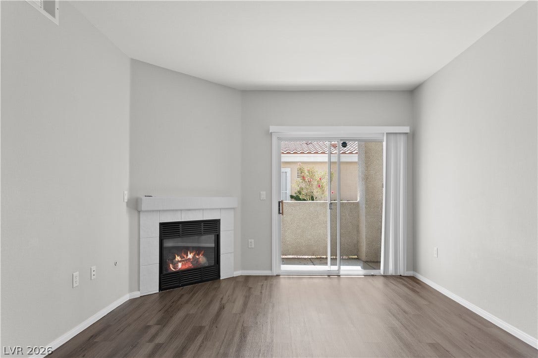 855 N Stephanie Street, #2615, Henderson, NV 89014 A cozy corner fireplace anchors this open room, featuring sliding glass doors to the balcony.