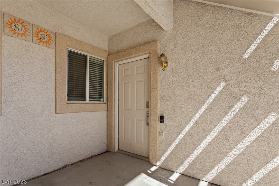 855 N Stephanie Street, #2615, Henderson, NV 89014 A welcoming entryway features textured stucco walls and a sheltered concrete porch.