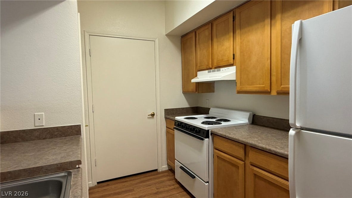 45 Maleena Mesa Street, #1912, Henderson, NV 89074 Ample wooden cabinetry and durable laminate countertops maximize utility in this functional kitchen layout.
