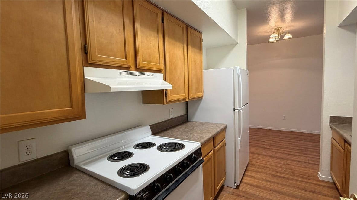 45 Maleena Mesa Street, #1912, Henderson, NV 89074 Ample wooden cabinetry and laminate countertops define this functional, galley-style kitchen space.
