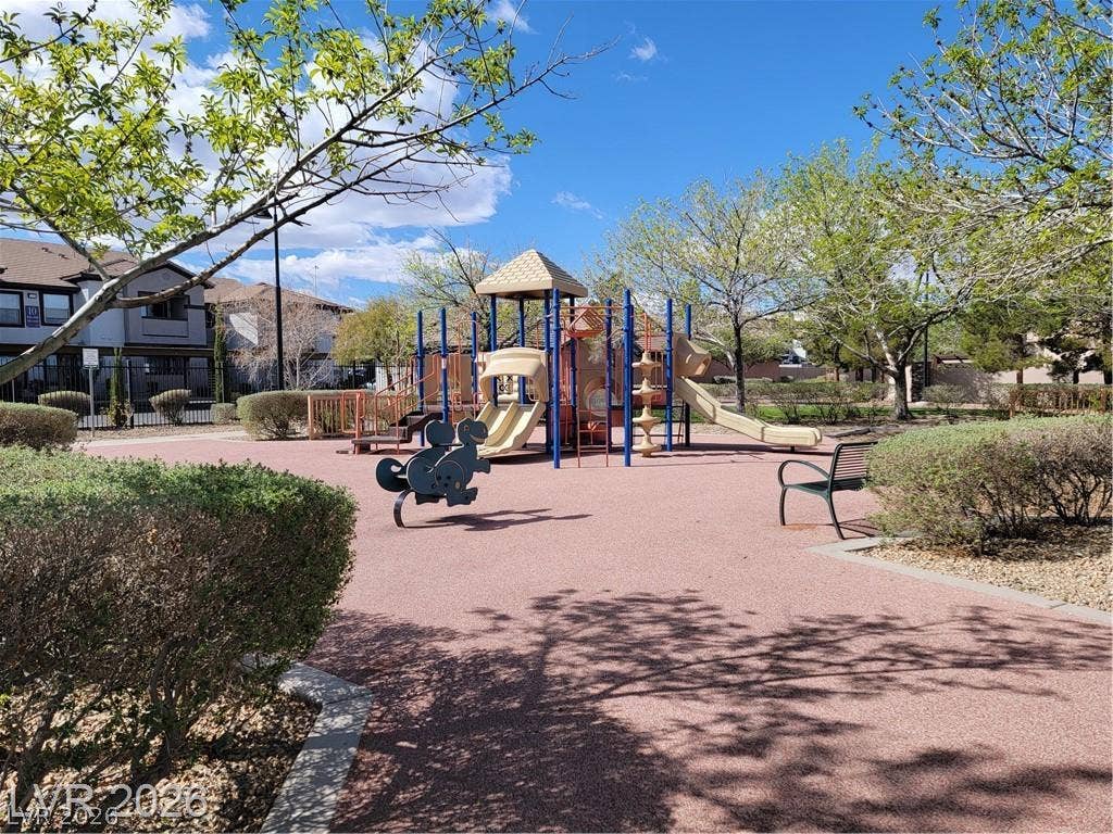 45 Maleena Mesa Street, #1912, Henderson, NV 89074 Mature trees shade a community playground set on safety surfacing under blue skies.