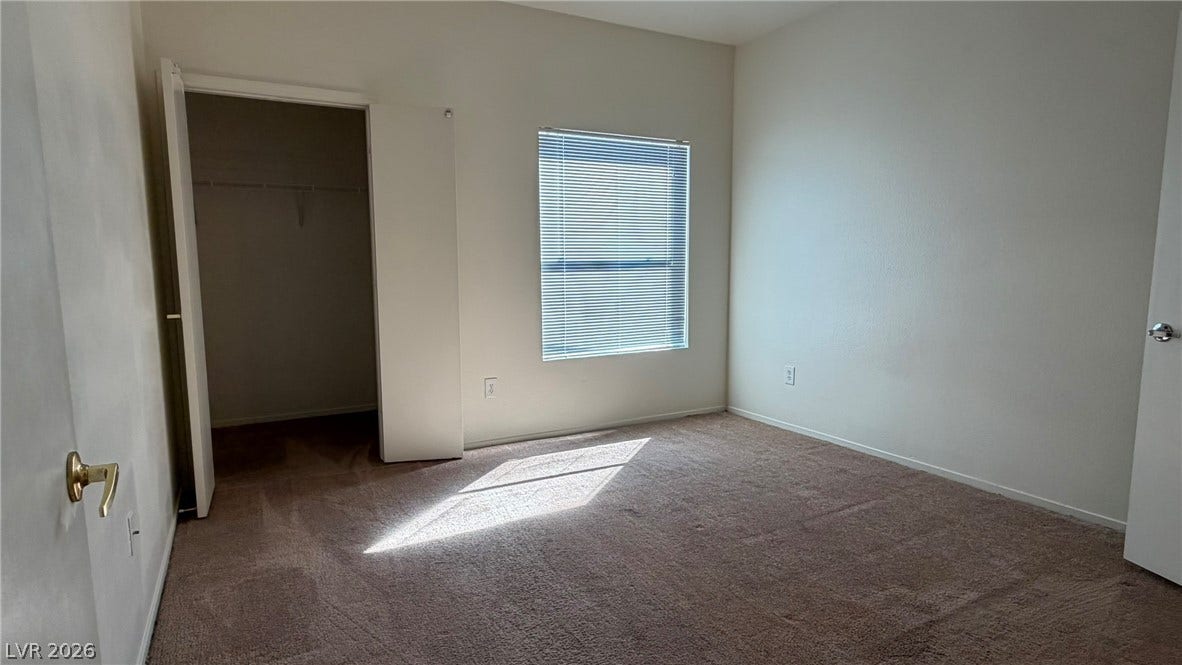 45 Maleena Mesa Street, #1912, Henderson, NV 89074 Natural light streams across carpeted flooring in this comfortable bedroom featuring a walk-in closet.