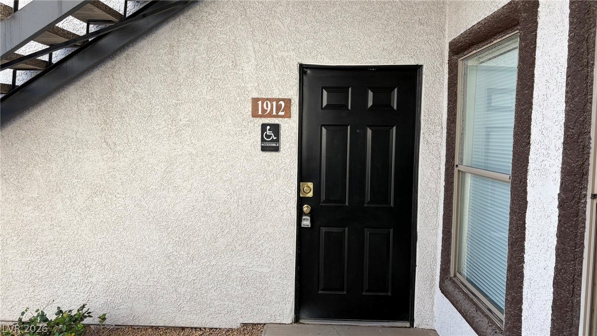 45 Maleena Mesa Street, #1912, Henderson, NV 89074 An inviting private entrance features a bold black paneled door and textured stucco siding.