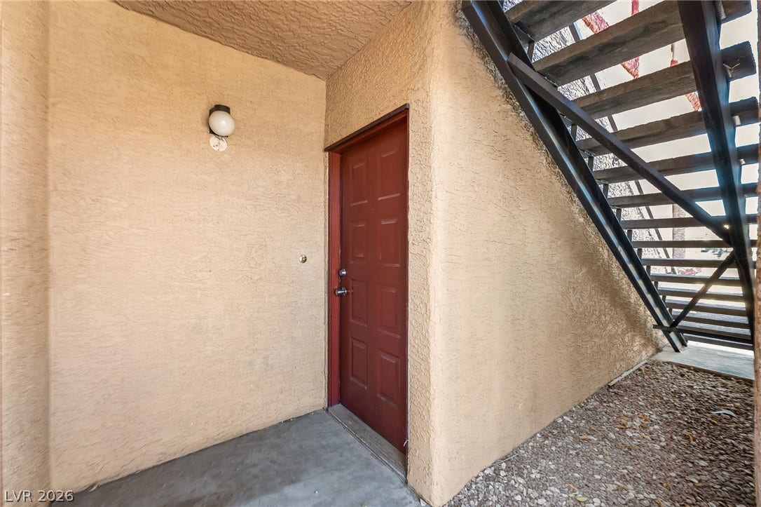 4340 Sanderling Circle, #78, Las Vegas, NV 89103 A private ground-floor entrance sits tucked beneath a metal staircase with stucco walls.