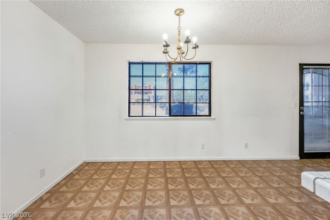 4340 Sanderling Circle, #78, Las Vegas, NV 89103 Patterned wood-look flooring and a classic chandelier define this versatile dining area.