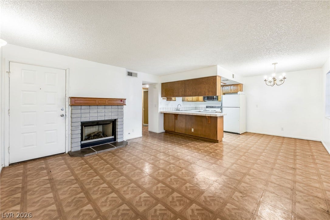 4340 Sanderling Circle, #78, Las Vegas, NV 89103 An open floorplan connects the living area, brick fireplace, and kitchen.