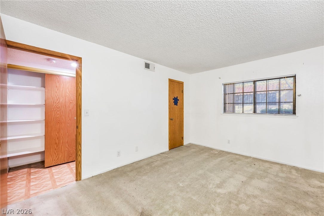 4340 Sanderling Circle, #78, Las Vegas, NV 89103 Plentiful natural light fills this bedroom featuring carpet flooring and built-in closet shelving.