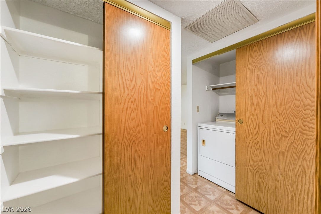 4340 Sanderling Circle, #78, Las Vegas, NV 89103 A functional laundry area provides built-in shelving alongside sliding doors for convenient hidden storage.