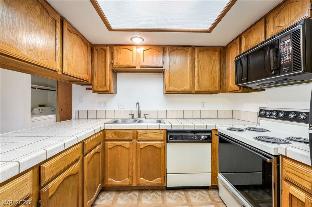 4340 Sanderling Circle, #78, Las Vegas, NV 89103 Oak cabinetry and tiled countertops define this functional culinary space.