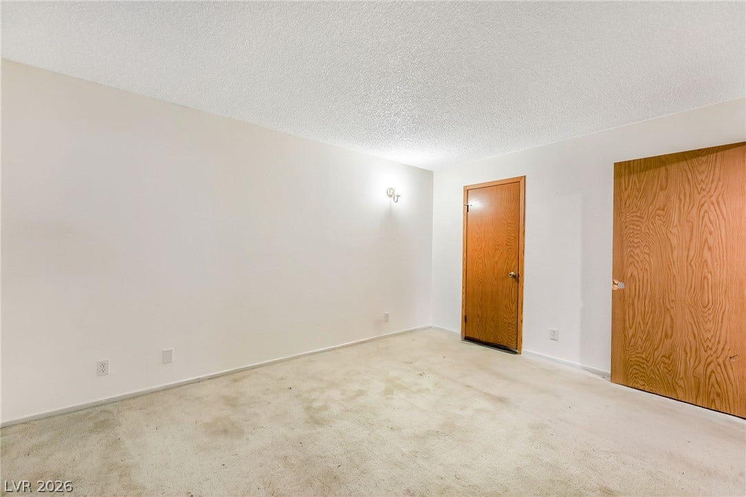 4340 Sanderling Circle, #78, Las Vegas, NV 89103 Natural wood doors contrast cleanly with light walls and carpeted flooring in this versatile space.