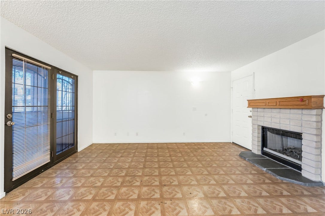 4340 Sanderling Circle, #78, Las Vegas, NV 89103 Patterned parquet floors and a classic brick fireplace anchor this versatile living area.