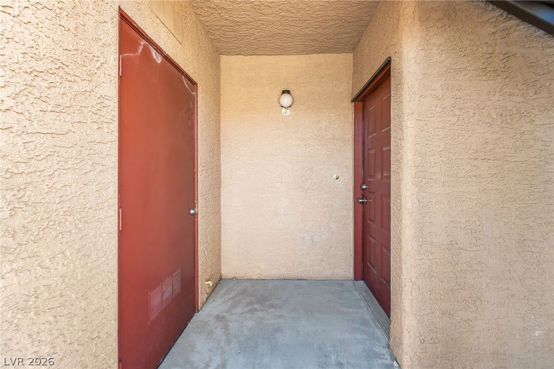 4340 Sanderling Circle, #78, Las Vegas, NV 89103 A sheltered concrete entry alcove sits flanked by textured stucco walls and solid doors.