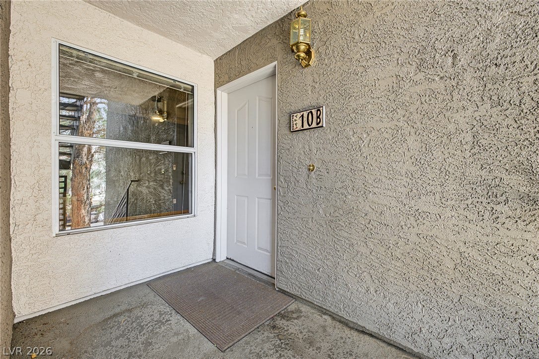 701 Capri Drive, #10B, Boulder City, NV 89005 A private entrance features textured stucco walls and a large adjacent window.