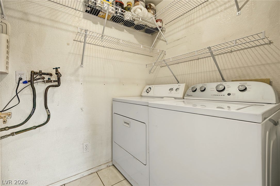 701 Capri Drive, #10B, Boulder City, NV 89005 A dedicated laundry space features tile flooring and convenient wire shelving installed above the appliances.