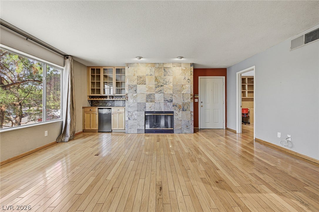 701 Capri Drive, #10B, Boulder City, NV 89005 Polished wood flooring runs throughout this living space anchored by a tiled fireplace.
