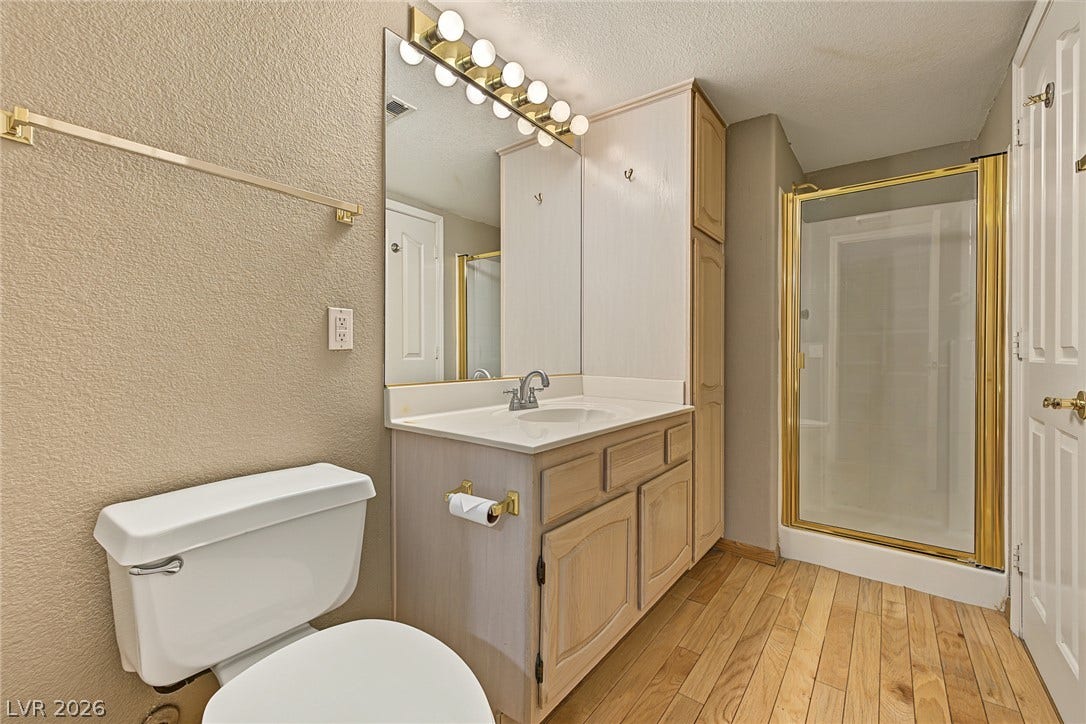 701 Capri Drive, #10B, Boulder City, NV 89005 Warm wood flooring pairs with a classic vanity setup in this functional bathroom space.