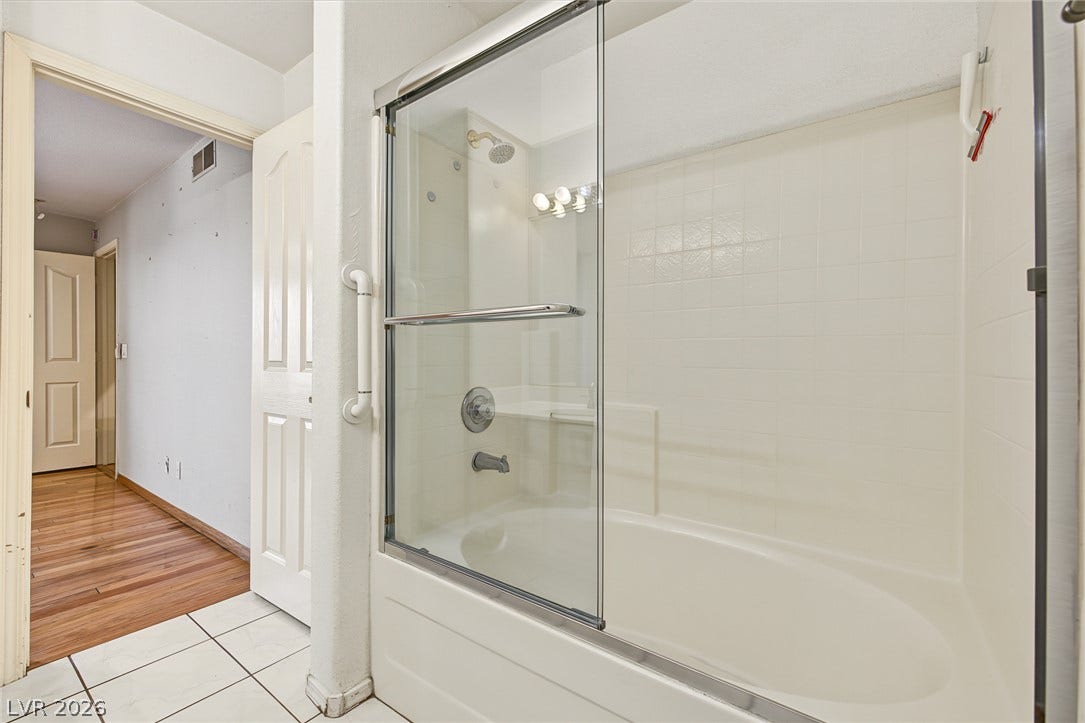 701 Capri Drive, #10B, Boulder City, NV 89005 Tiled flooring and a glass-enclosed tub shower combination define this bathroom space.