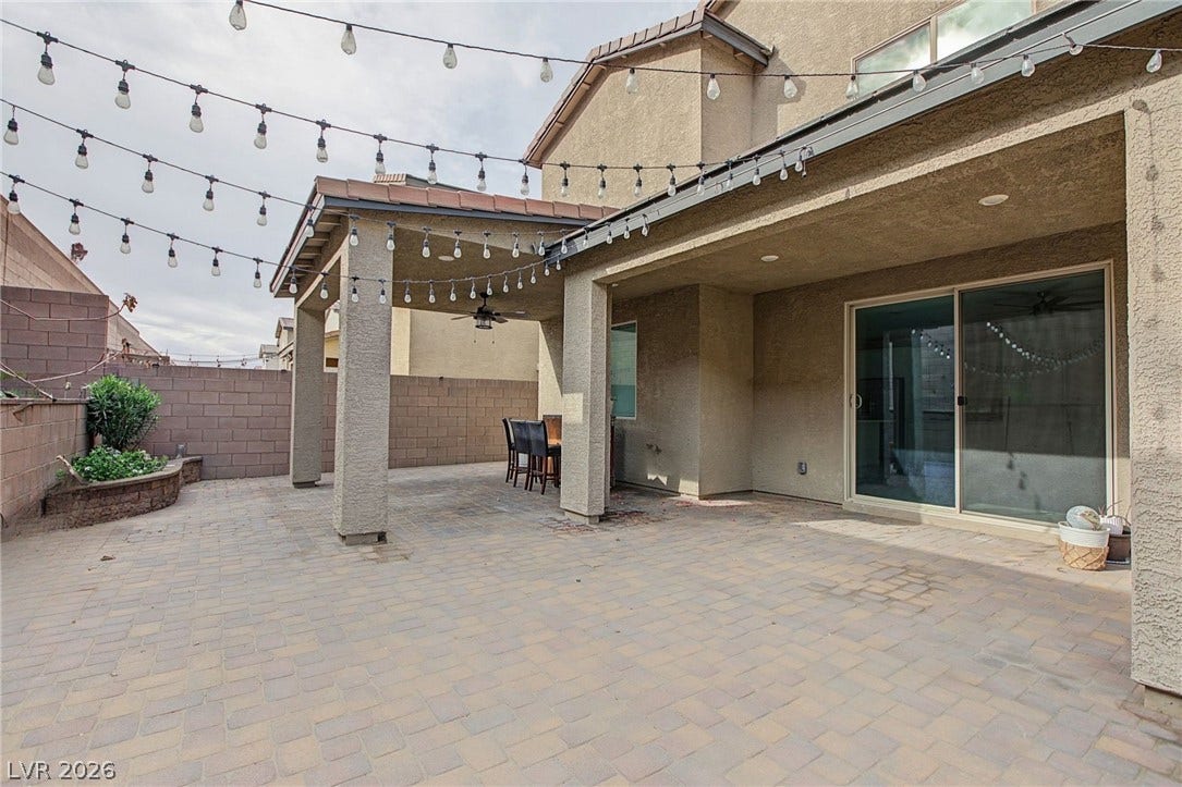 2728 Lindsey Springs Street, Las Vegas, NV 89142 An inviting brick paver patio extends beneath a covered portal with glass sliding doors.