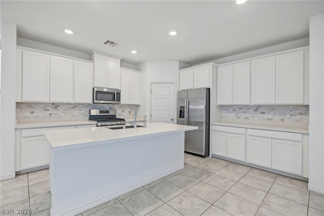 2728 Lindsey Springs Street, Las Vegas, NV 89142 Bright tile floors and quartz countertops anchor this modern kitchen with a central prep island.